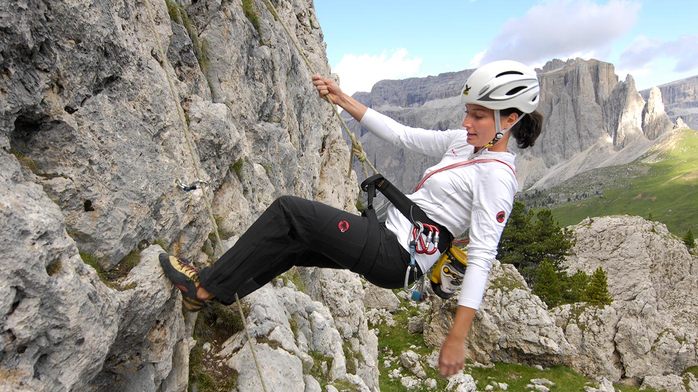 Una ragazza scala una parete rocciosa