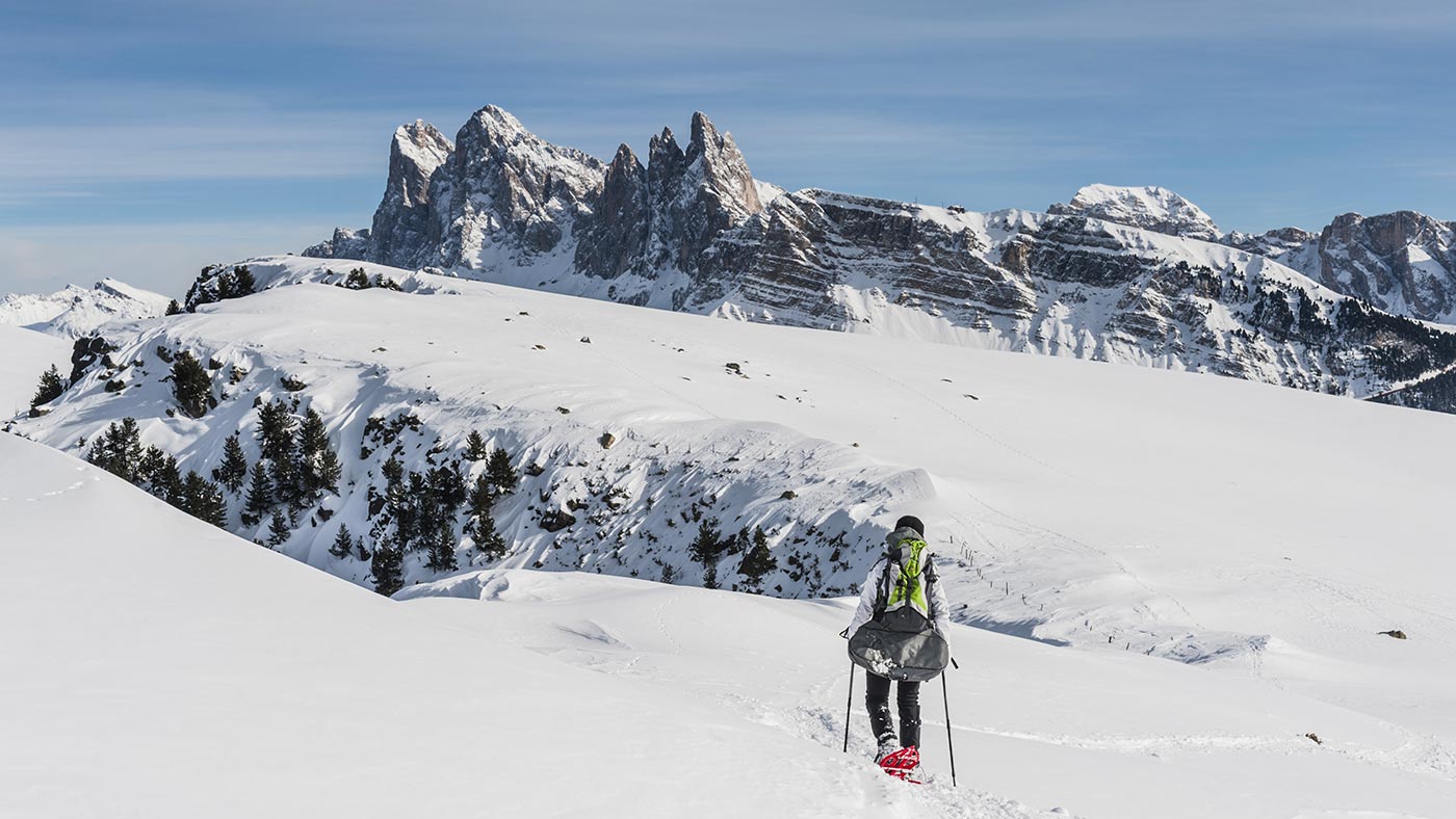 Un ragazzo cammina con le ciaspole nel cuore delle Dolomiti