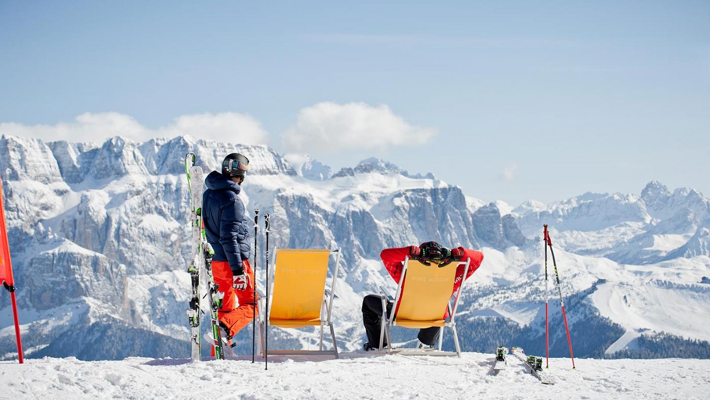 Zwei Freunde genießen den Blick auf das Skigebiet Sellaronda